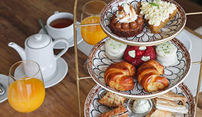 Mesa de té para dos completa, con bebidas calientes, jugo de naranja natural, y bocados dulces y salados